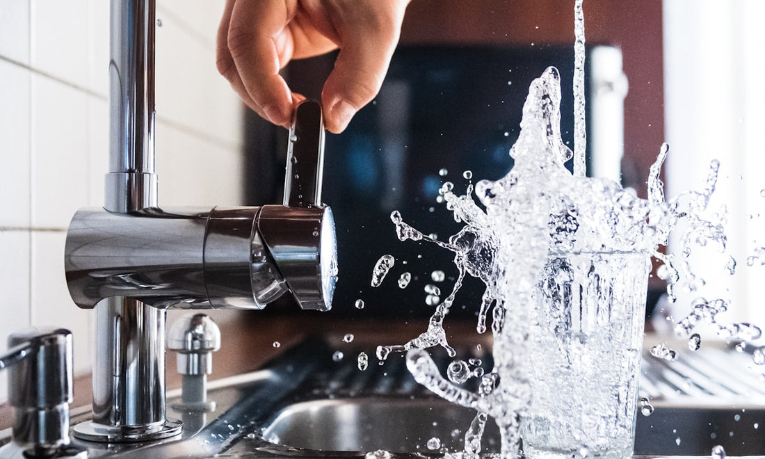 Filling a glass of water at a kitchen tap